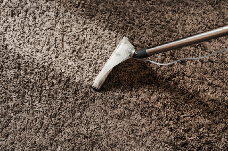 Close up of compressed carpet fibers showing dirt accumulation and matting in high traffic areas of old carpet